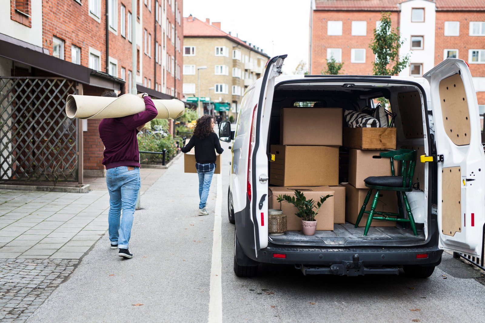 Umzugshelfer des Umzugsservices entladen Kartons aus Transporter